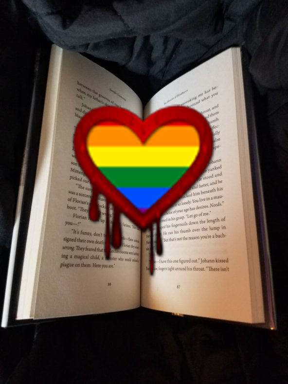 LGBTQ+ horror with a rainbow hear dripping with blood over a book