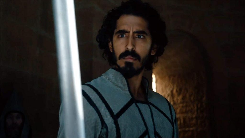 A still of Dev Patel holding Excalibur as Gawain from 2021's The Green Knight