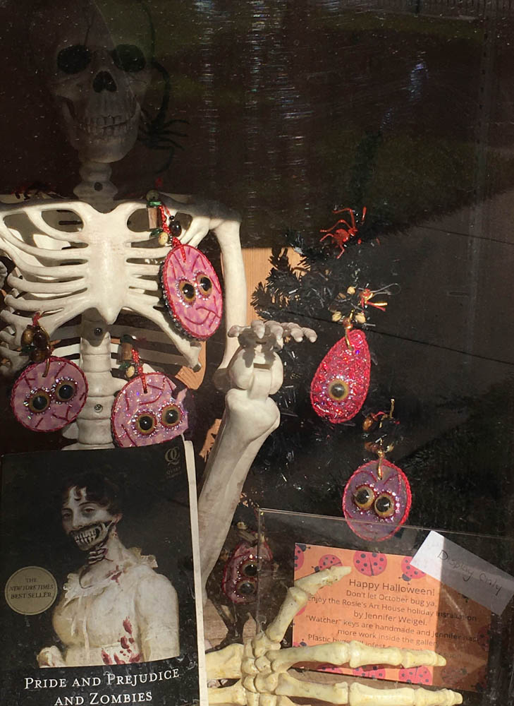 detail of little library display after the rat left, with a faux skeleton hand and sign about the artwork