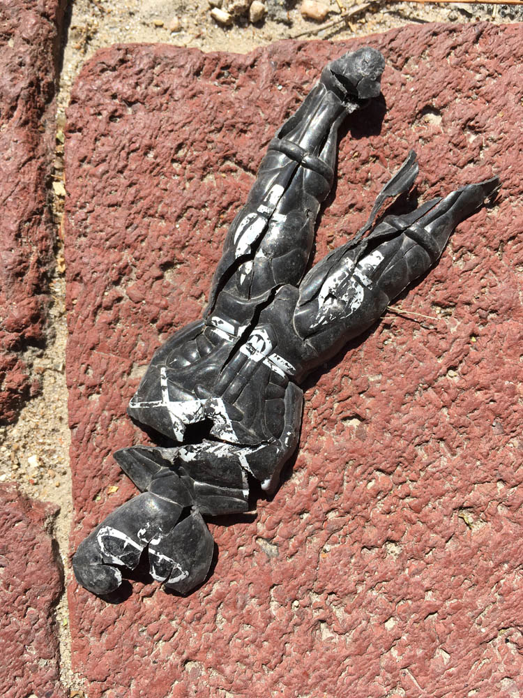 A spent soldier action figure lay crushed in the street, a casualty of the war.