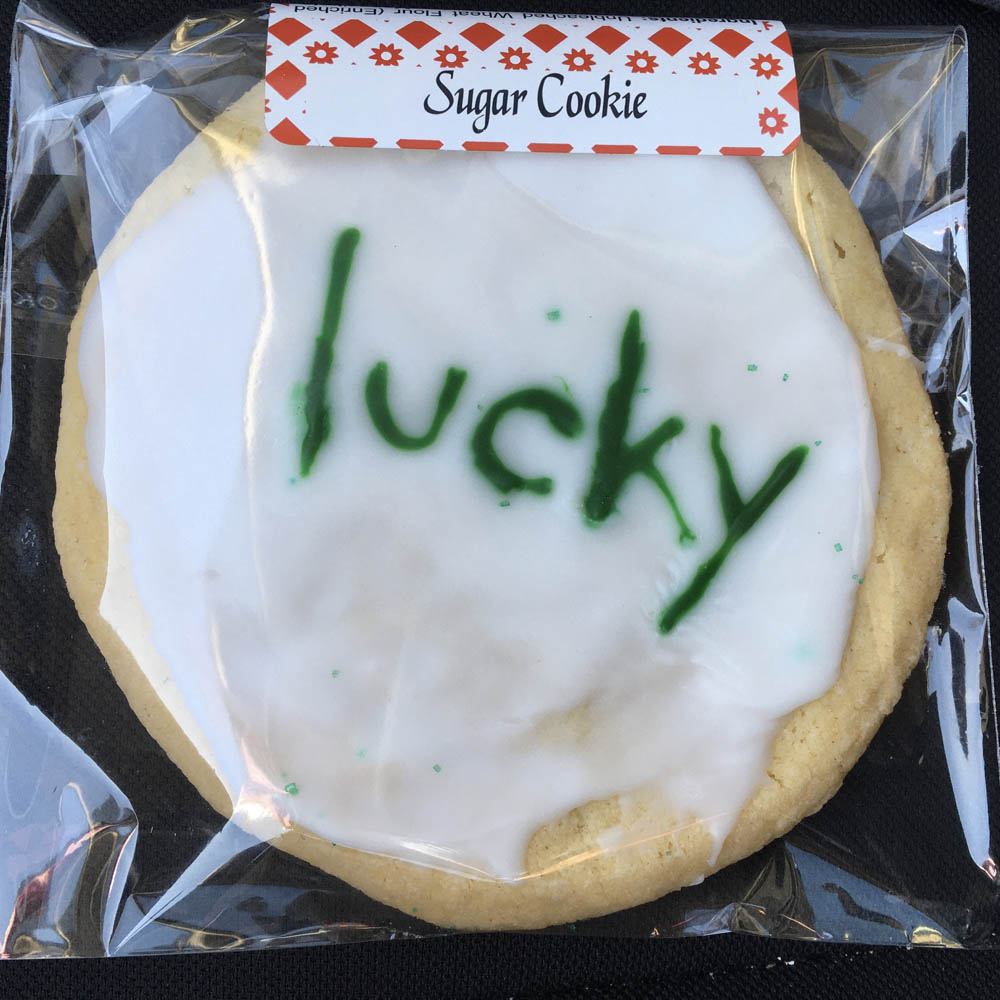 A sugar cookie, frosted and emblazoned with the word "lucky" in green on white for St. Patrick's Day