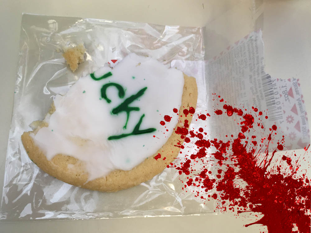 Blood spattered across the rest of the cookie, now reading "ucky" after being partially eaten