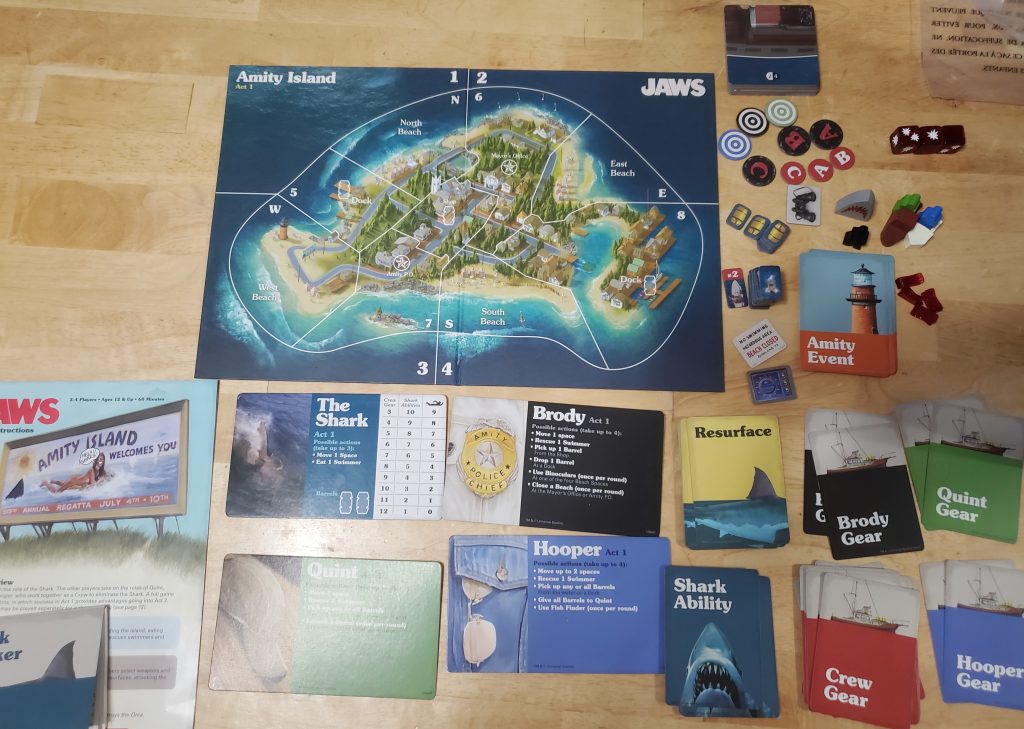 The Jaw's board game components laid out on a wooden table.