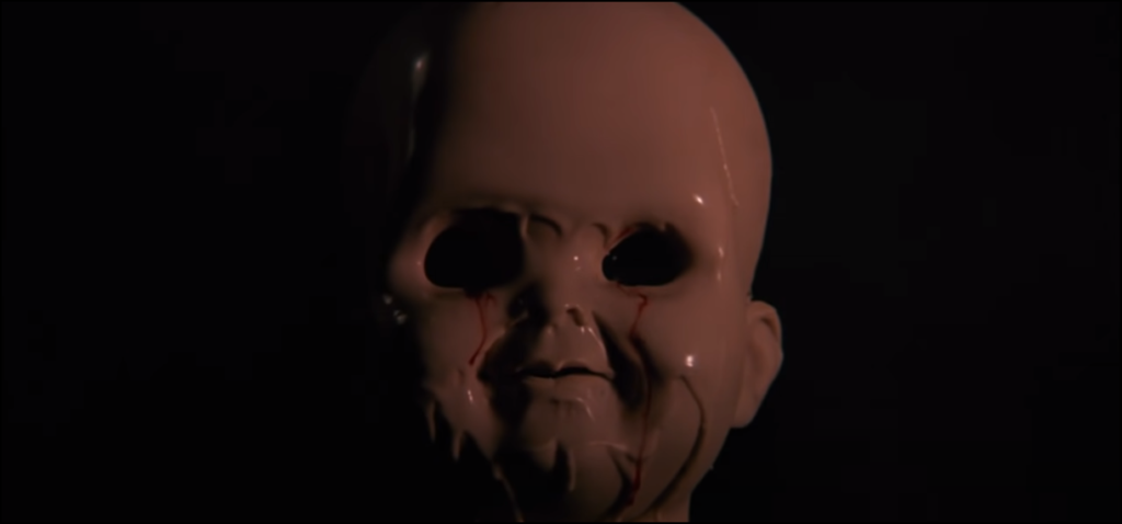 'Child's Play 3' - screenshot of a waxy, melting Chucky from the opening credits