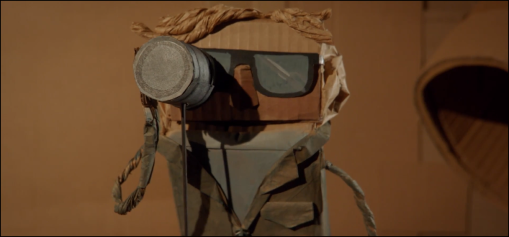 Cardboard puppet Harry (James Urbaniak) keeps shooting in the labyrinth