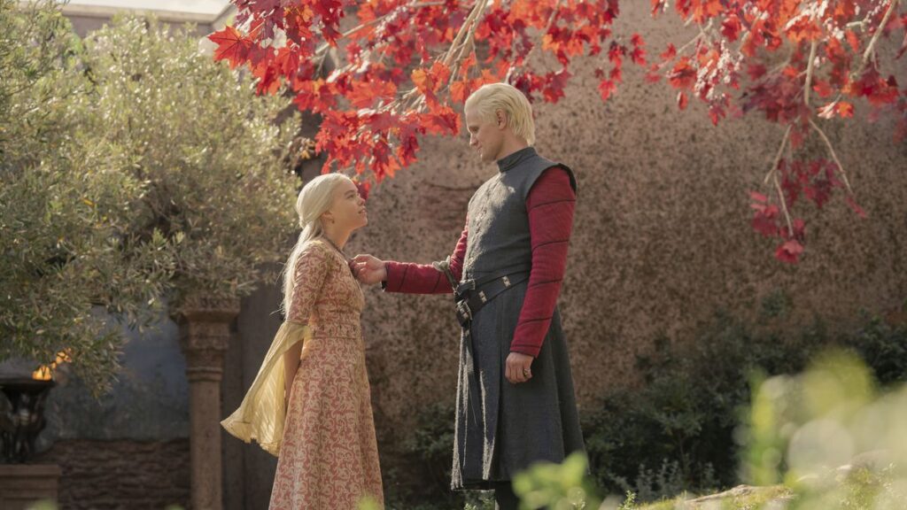 An intimate moment between Rhaenyra and Daemon. He touches her necklace under a tree.