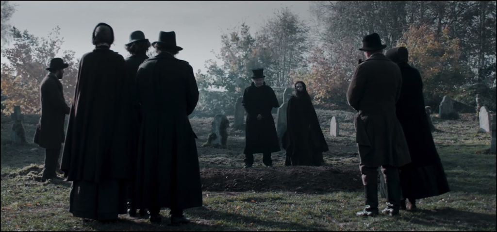 A still from 'Raven's Hollow' (2022) - a still depicting a funeral