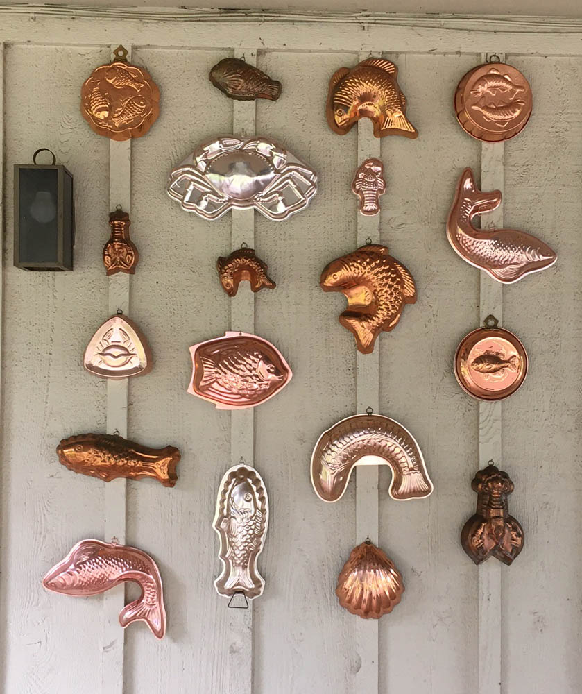 My copper fish mold collection, as shown hanging on my outside covered porch.