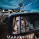 Marionette Cover Art: Woman looking through a rearview mirror in a small town