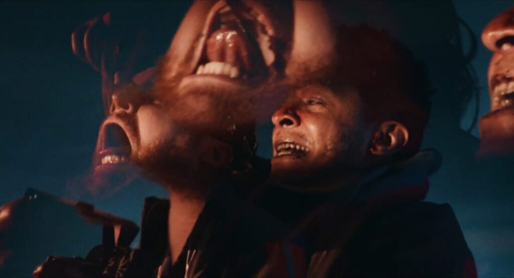 kaleidoscopic image of Benny and Roscoe tripping on the films hallucinogenic worms. Both men have looks of sheer terror riddled on their faces. Benny's mouth is open wide screaming while Roscoe sits to his right gritting his teeth anxiously. 