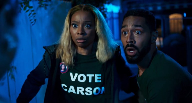 Woman and man wearing a vote for candidate shirt, scared of something off screne