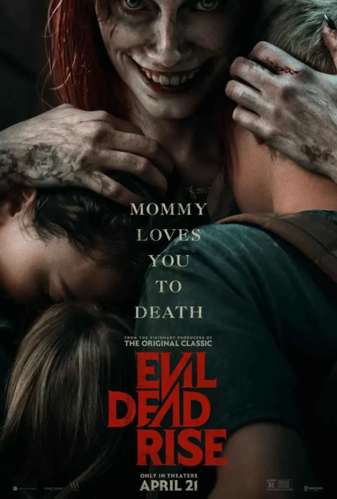 Official poster for Evil Dead Rise. The image features Alyssa Sutherland as Ellie holding her characters 2 children and younger sister beth. A sharp sinister smile floods her face as her demonic yellow eyes pierce the soul. Her Hands cradle her son and sister's heads in either hand. On her right hand we see a floral vine tattoo that wraps down her pinky, he left hand is injured and bloody. The Words "Mommy Loves You To Death" printed in white run down the poster above the film's title 'Evil Dead Rise'. The bottom of the poster provided the official release date of April 21st. 