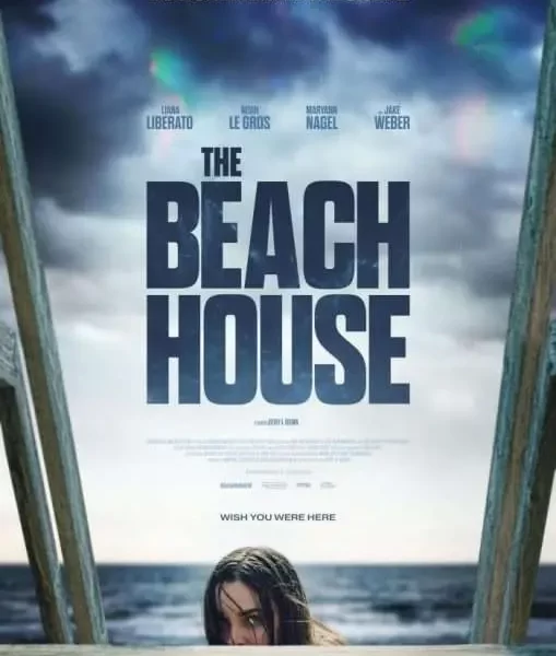 "The Beach House" stated directly in the middle of the poster. Above is a stormy sky, below is the beach with a woman poking her head above a staircase.