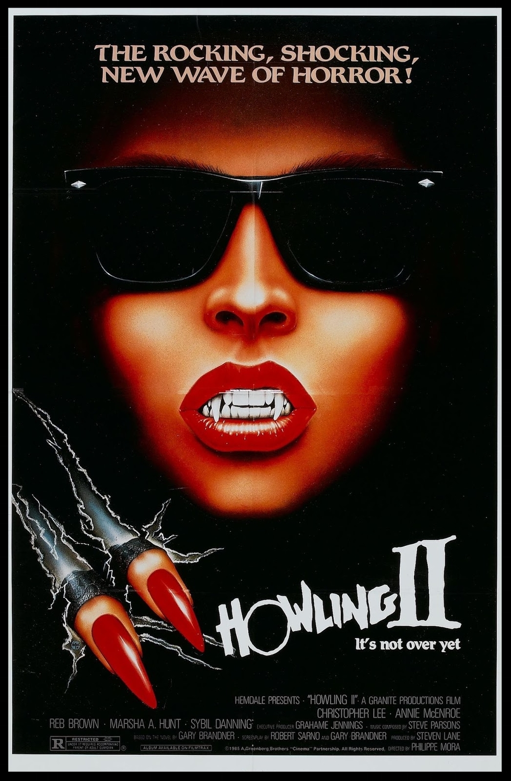 Woman with long canines carves two fingers through the black cover. Howling II written in white underneath.
