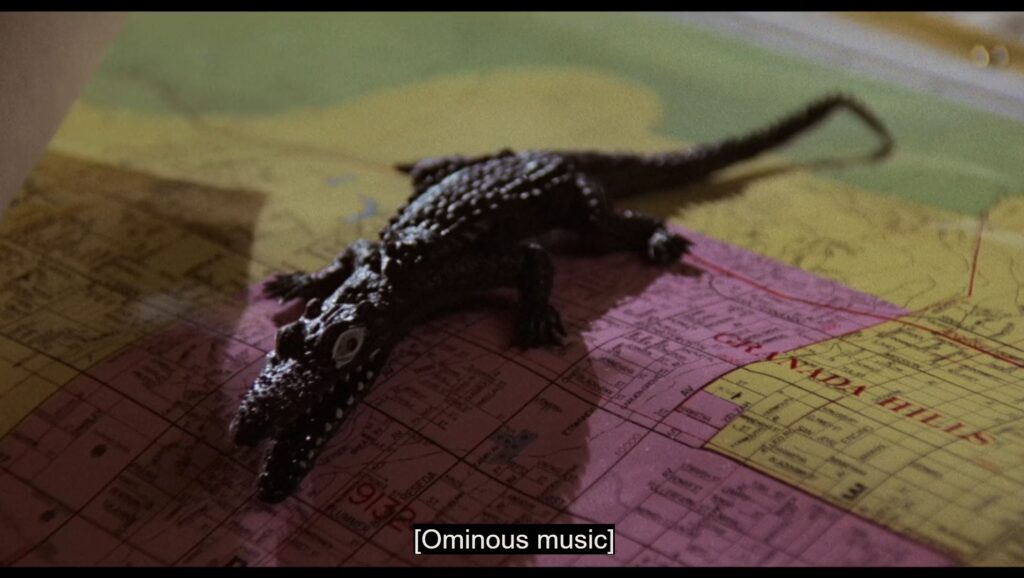 A small alligator sits on a map of Chicago.