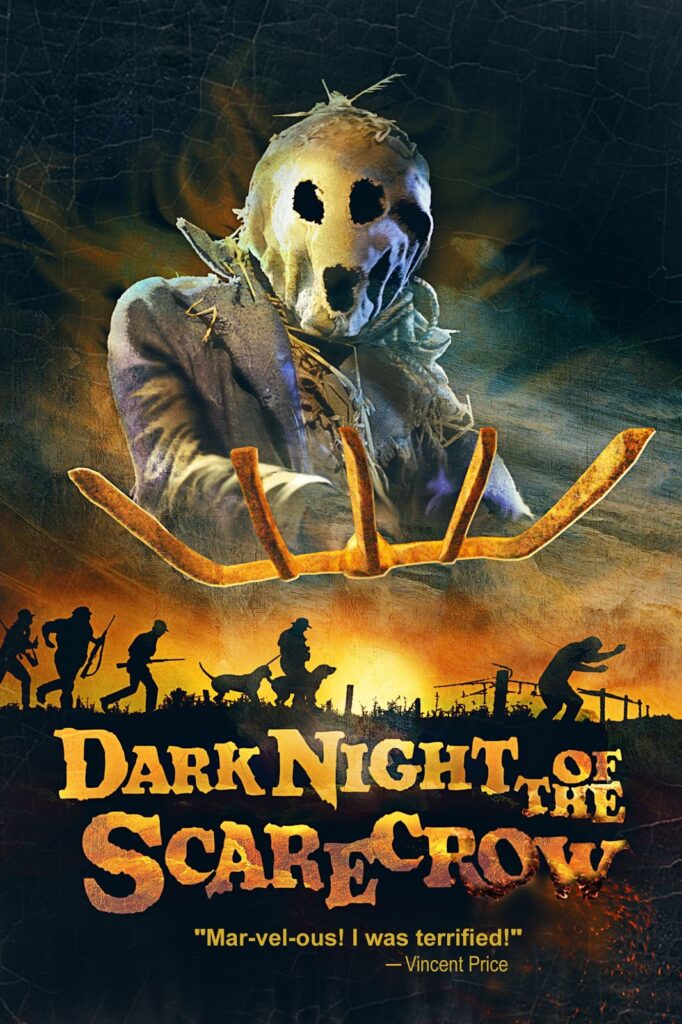 A poster for the folk horror classic Dark Night of The Scarecrow. A large scarecrow holds a pitchfork towards the viewer. There are shadows showing men with guns and dogs in a field beneath the scarecrow.