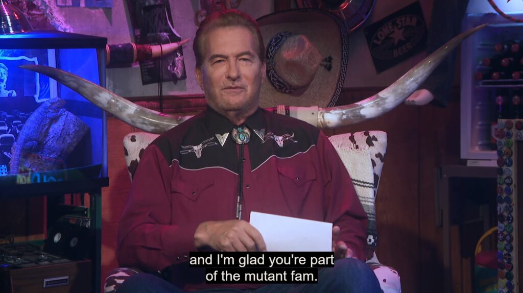 Joe Bob Briggs sit in his longhorn chair reading a fan mail letter. He is saying "...and I'm glad you're part of the mutant fam."