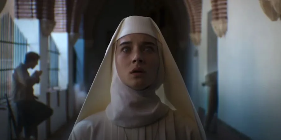 A young woman aspiring to be a nun looks up in confusion. She is in a hall, assumedly in a convent