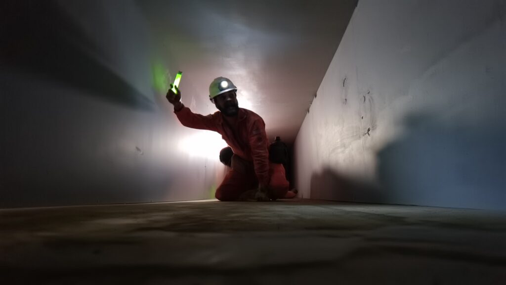 A first responder waving a glowstick to see down a dark corridor