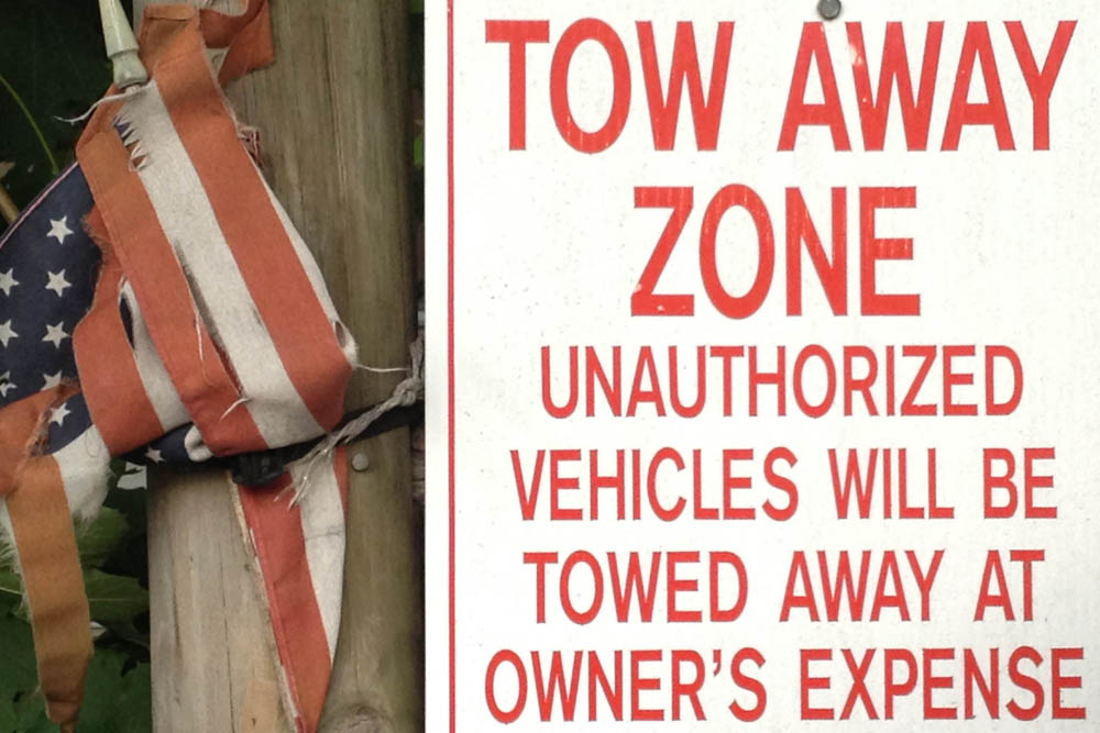 Tow Away Zone photograph of sign and flag as found by Jennifer Weigel