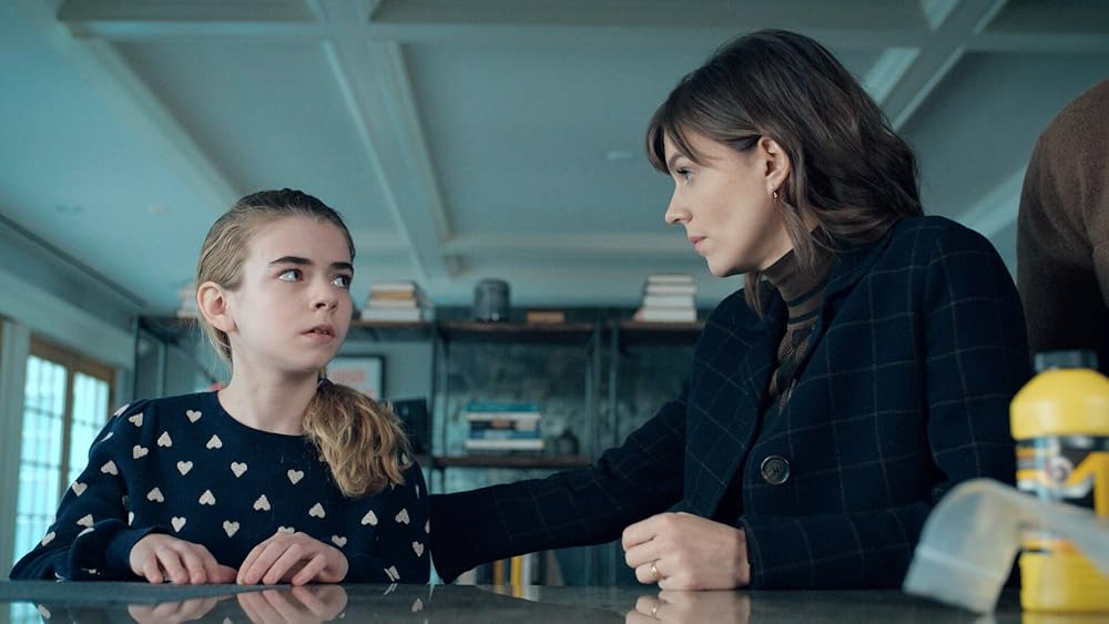 A little girl looks up at a woman in a kitching setting