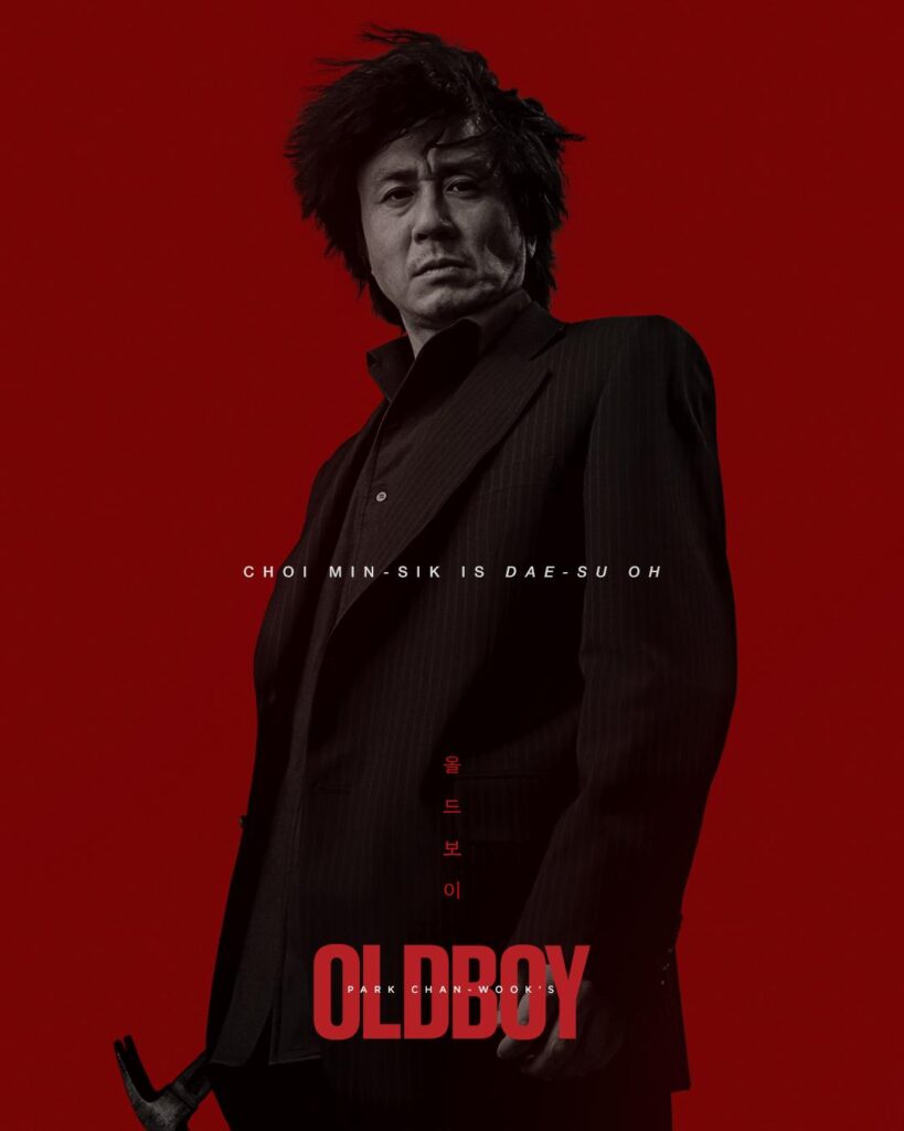 A man in black stands against a red background, holding a slightly obscure hammer. Below him reads Oldboy in red. 