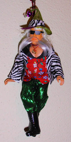 Santa doll dressed in zebra coat, satin pants, and fancy floral shirt with necklace, sunglasses, and fancy green mesh hat with zebra accent and purple bell "Pimpin his Ho Ho Hos"