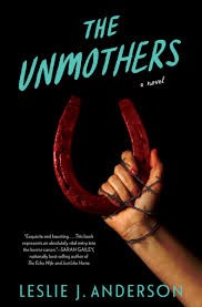 The Unmothers book cover. A hand holding up a horse shoe covered in blood on a black background.