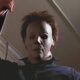 Michael Myers has a kitchen knife raised staring at something off-screen.