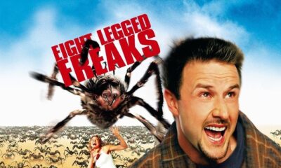 David Arquette is looking above mid yelling about something as a giant spider is behind him. EIGHT LEGGED FREAKS is in large red letters in the background of a blue sky.